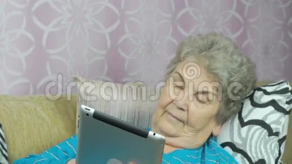 老祖母在室内持有平板电脑视频的预览图