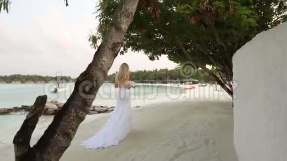 年轻新婚夫妇的第一眼新娘去白色沙滩上浪漫的热带小岛参加婚礼视频的预览图
