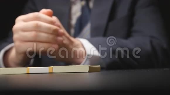 布里伯商人从一张桌子上拿出一个钱包在谈判时穿上西装隐藏摄像头视频的预览图