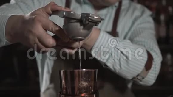 男手调酒师在做鸡尾酒时在摇杯中挤柠檬汁视频的预览图