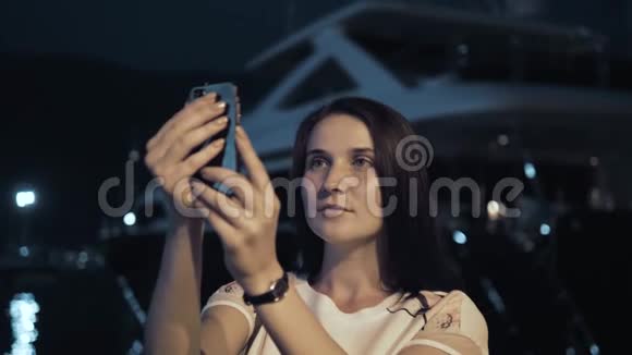 勇女用智能手机拍照时尚的夏日旅行者女性带电话户外在欧洲城市夜湾视频的预览图