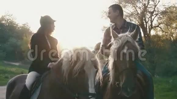 特写一对职业骑师骑着马在乡间小路上互相交谈和微笑视频的预览图