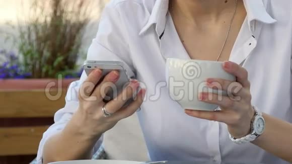 女士在咖啡屋早餐时使用智能手机视频的预览图