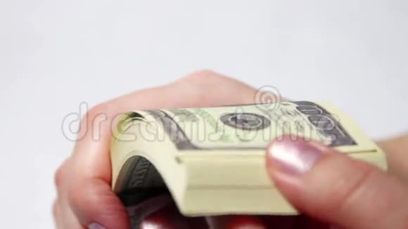 女人的手在白色背景缓慢移动着一捆美元视频的预览图