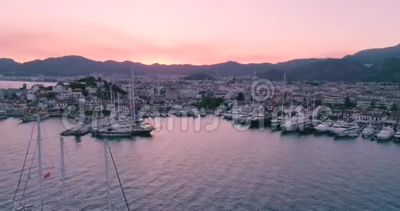 在马尔马里斯日落时可鸟瞰船只游艇和城市视频的预览图