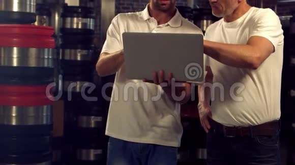 酿酒工人在笔记本电脑上查看信息视频的预览图