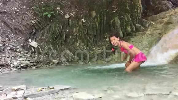 女孩穿着泳衣在山上瀑布的湖里洗澡少年少年少年视频的预览图