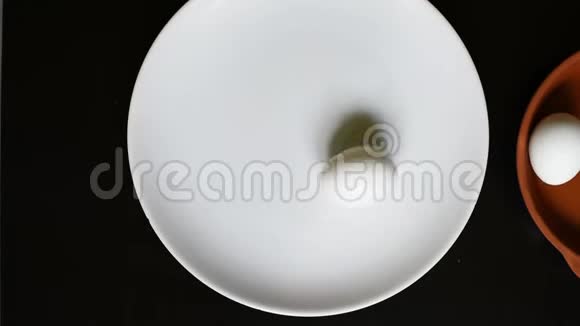 黑桌背景上白色盘子上煮鸡蛋视频的预览图