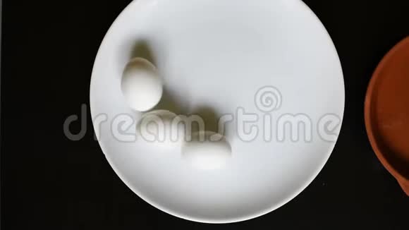 黑桌背景上白色盘子上煮鸡蛋视频的预览图