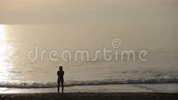 站在海边夕阳下的人们剪影女人时间推移视频的预览图