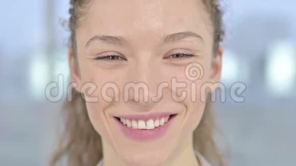在镜头前微笑的年轻女人视频的预览图