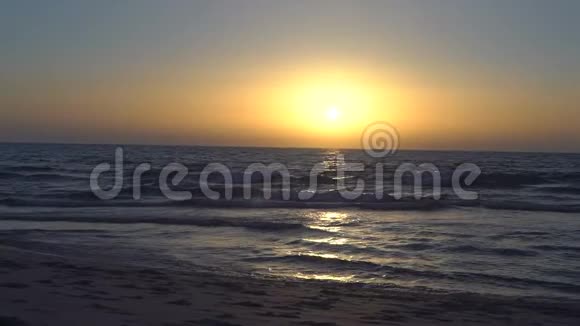 大海或海洋上令人惊叹的日落晴朗的天空平静的大海带着小浪波浪在沙子上荡漾从视频的预览图
