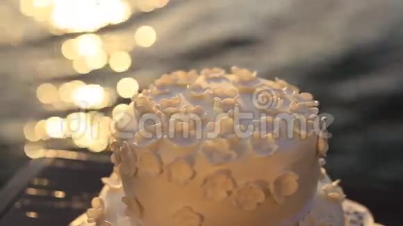 海滩上的婚礼蛋糕阳光照耀在水面上韦迪丁视频的预览图
