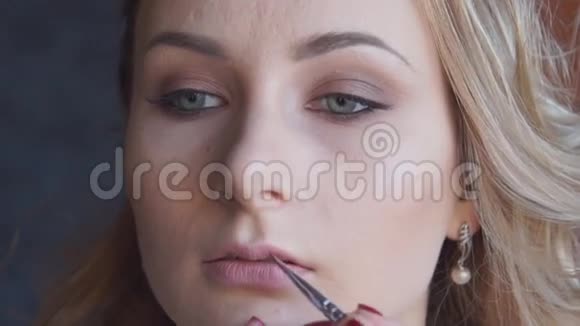 化妆过程化妆艺术家在年轻女性的脸上奠定基础化妆艺术家用刷子为视频的预览图