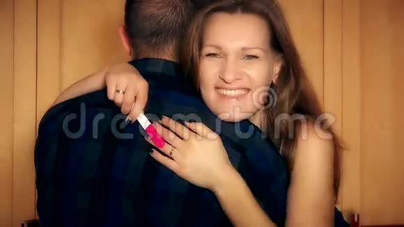 快乐的一对夫妇在家拥抱怀孕测试积极情绪视频的预览图