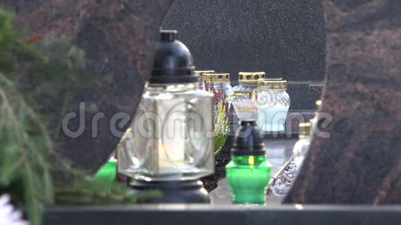 在城市墓地的坟墓上蜡烛透过玻璃覆盖4K视频的预览图