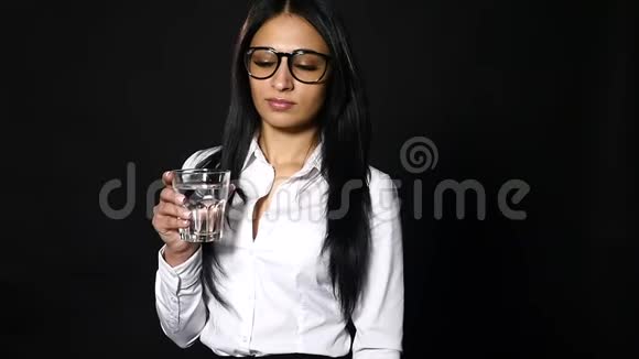 女商人拿着一杯水和饮料被隔离在黑色背景上视频的预览图