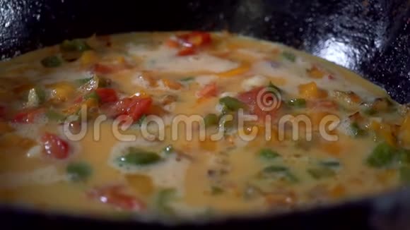 慢动作晚餐用鸡蛋和红椒在煎锅中煮熟视频的预览图