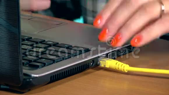 女性手断开互联网局域网电缆到笔记本电脑特写视频的预览图