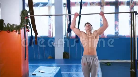年轻的肌肉男在水平杆上锻炼视频的预览图