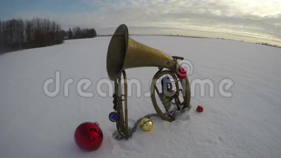 带圣诞装饰的雪地上的老式黄铜乐器延时4K视频的预览图