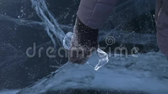 穿着手套的人在冰上扭冰慢动作相机在冰后移动一块冰真的视频的预览图