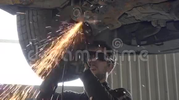 带眼镜切割的机械师在车库用磨床磨损汽车零件视频的预览图