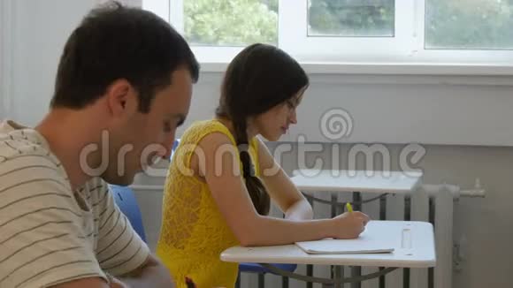 两个学生在教室里写笔记视频的预览图