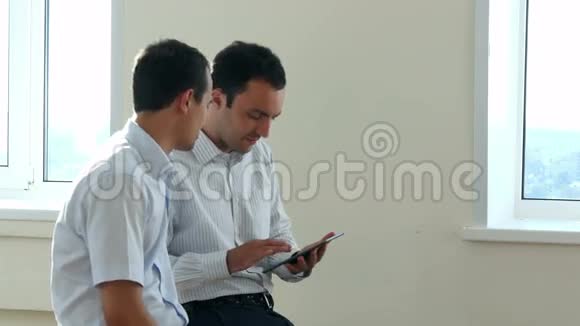 两位企业高管坐在一个明亮的办公空间里通过共享一个视频的预览图