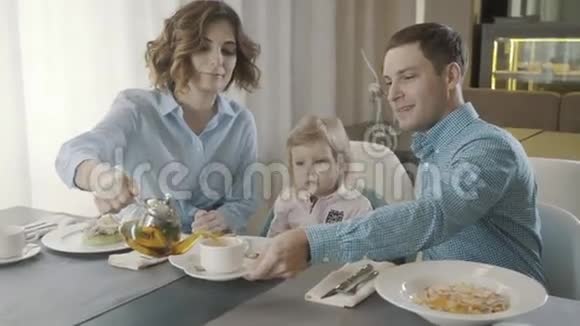 一家餐馆里有个小孩的家庭爸爸妈妈和女儿视频的预览图