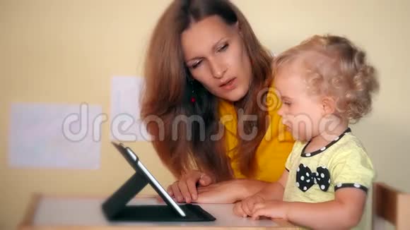 玩女人和蹒跚学步的女儿使用平板电脑视频的预览图