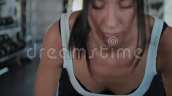 漂亮的运动女人在健身房做举重视频的预览图