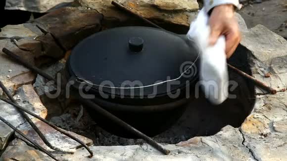 乌兹别克民族菜皮拉夫在一个大型铸铁大锅上着火混合现成皮拉视频的预览图