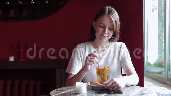 咖啡店窗口附近喝茶的年轻女子的肖像视频的预览图
