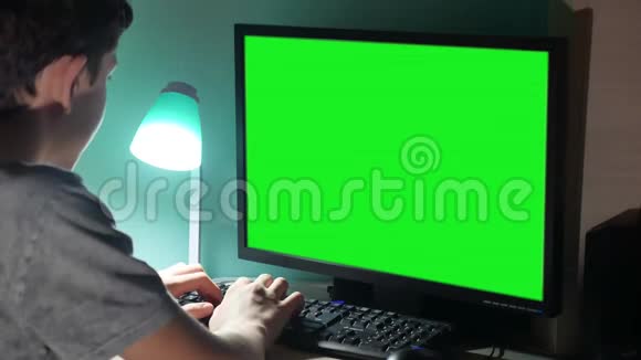 绿色钥匙室内青少年男孩玩电脑特写手游视频后坐青年室内学生考试视频的预览图