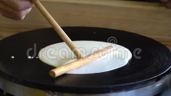 厨师把面糊放在煎锅里在煎锅上做煎饼视频的预览图