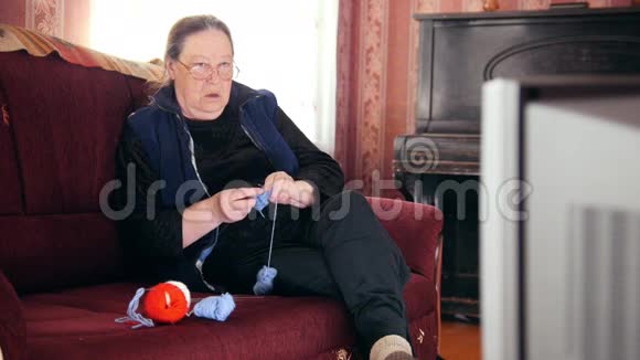 一位在家看电视的老太太的肖像羊毛袜子视频的预览图