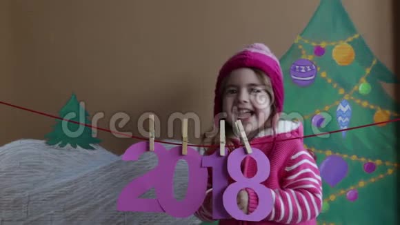 新年2018概念美丽的小女孩装饰新年数字一棵彩绘圣诞树的背景视频的预览图