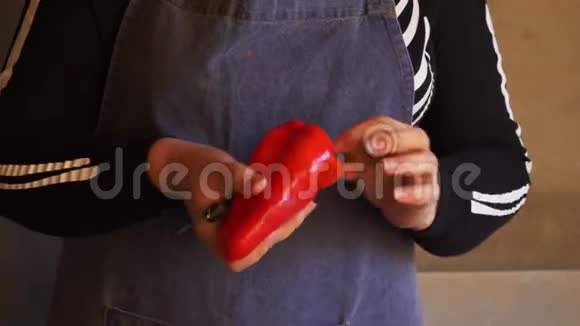 年轻的女厨师穿着骷髅服装和围裙切红甜椒并清洗冷冻视频的预览图