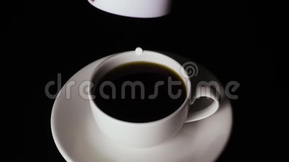 药片中的替代糖落在黑色背景上的杯子里慢动作视频的预览图