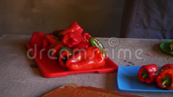 年轻的女厨师穿着骷髅服装和围裙切红甜椒并清洗冷冻视频的预览图