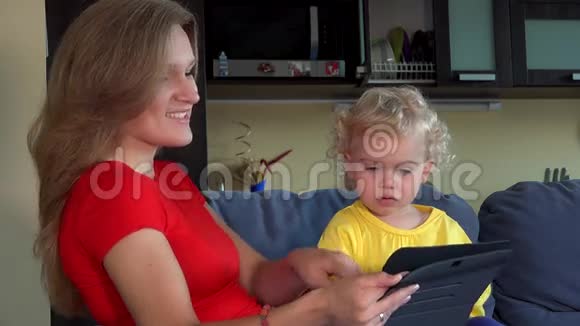 快乐的母亲带着卷发的孩子挥手把一个吻扔到平板电脑上视频的预览图