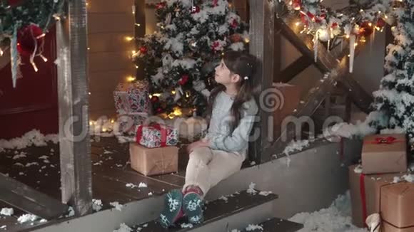 圣诞节或新年小女孩手里拿着一个盒子手里拿着礼物狡猾地微笑着孩子收到了许多礼物视频的预览图