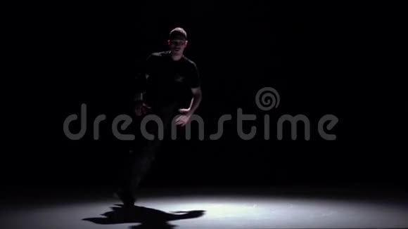 现代跳脱衣舞的男子手舞黑色阴影慢动作视频的预览图
