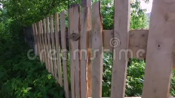 女孩子打开木门靠近zaschelku的木栅栏中的木门视频的预览图