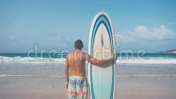 年轻的宽肩男站在海滩上视频的预览图