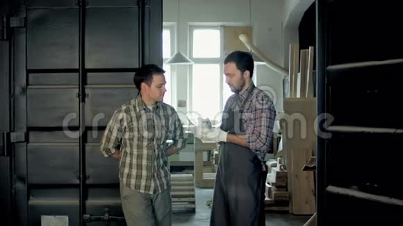 工厂里的两个木工在讨论一些事情视频的预览图