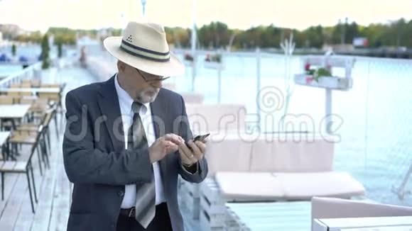 老人在露天咖啡馆用手机4K视频的预览图
