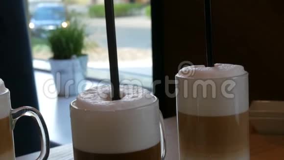 在桌上的咖啡馆里带咖啡拿铁和大泡沫的漂亮眼镜视频的预览图