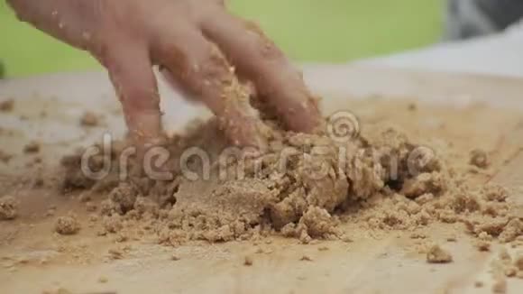 在木切割板上捏合全麦面粉面团视频的预览图